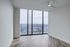 Bright empty room with large windows overlooking a panoramic cityscape.
