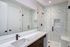 Sleek modern bathroom with white marble tiles, shower enclosure, and stylish vanity.