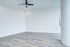 Bright, open room with sophisticated wood flooring and a stylish ceiling fan.