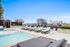 Luxurious urban rooftop pool deck with stylish loungers and city skyline views.