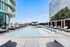 Elegant rooftop pool with modern lounge chairs and cityscape view.