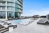 Elegant pool area with modern loungers and a stunning city view backdrop.