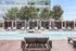 Elegant poolside area with loungers, cabanas, and serene water features.