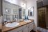 Modern bathroom with dual sinks, sleek mirrors, and decorative touches.