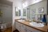 Modern bathroom with twin sinks, sleek countertops, and stylish decor, featuring a cozy bathtub.