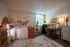 Inviting bedroom with a plush bed, stylish desk, and decorative accents including wall art and plants.