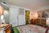Warm and inviting room with eclectic decor, featuring a cozy armchair, textured rug, and stylish wall art.