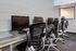 A modern computer lab featuring multiple workstations with sleek monitors and ergonomic chairs, ideal for study or work.