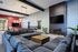 Spacious lounge with modern decor, featuring a large sectional sofa, stylish lighting fixtures, and a flat-screen TV.