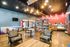 Inviting cafe interior with comfortable seating, modern lighting, and a wide selection of refreshments.