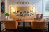 Inviting home office with vintage decor, vibrant chairs, and artistic wall display.