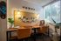 Inviting workspace with a double desk setup, colorful bulletin board, and large window view.
