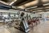 Well-equipped gym with modern cardio machines, weights, and exercise bikes in a spacious setting.