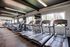 Modern gym with multiple treadmills and large windows offering natural light.