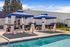 Inviting poolside area with blue cabanas featuring comfortable seating and elegant decor.