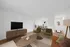 Stylish open-plan living room with modern wooden furniture, cozy seating, and elegant decor.