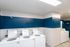 Bright and efficient laundry room with multiple washers and stylish blue accents.
