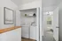 Bright laundry nook with modern washer and dryer, adjacent to a cozy bedroom.