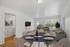 Bright open living room with modern decor, featuring a cozy seating area and elegant dining setup.