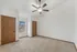 Bright bedroom featuring plush carpeting, two wooden doors, and a ceiling fan with light.