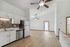 Bright open kitchen with modern cabinets and stainless steel appliances, leading to a spacious living area.