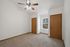 Inviting bedroom with plush carpet, ceiling fan, and ample natural light from a window.