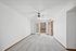 Spacious living room with carpeted floors, ceiling fan, and double doors leading to a balcony view.