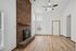 Inviting living room featuring a rustic brick fireplace, vaulted ceilings, and abundant natural light.