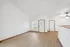 Bright and open living space with wooden flooring and vaulted ceilings.