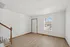 Inviting, sunlit entryway featuring elegant hardwood floors and a wooden staircase.