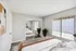 Modern bedroom with elegant decor, mirrored closet doors, and large window providing ample natural light.