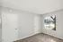 Spacious room with carpet flooring and large window overlooking a pool, featuring minimalistic design.