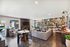 Inviting modern living area with stylish decor, large windows, and cozy seating by the fireplace.