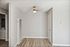 Bright and minimalist apartment space with modern ceiling light, hardwood flooring, and neutral color palette.