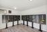 Modern apartment mail room features numerous black mailboxes with numbered slots, installed on a sleek wooden floor.