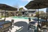Inviting outdoor swimming pool surrounded by modern patio furniture and large umbrellas.