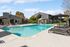 Inviting outdoor swimming pool with lounge chairs, surrounded by modern apartment buildings and lush greenery.