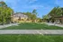 Inviting community courtyard with lush greenery, pavilion seating, and modern BBQ area on a sunny day.