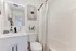 Modern bathroom with stylish decor, white vanity, and patterned shower curtain.