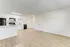 Bright open kitchen with modern white cabinets and sleek flooring.