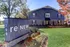 Elegant apartment building at ReNew West Durham with a well-maintained lawn and vibrant flowerbeds.