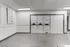 Modern laundry room with stackable washers and dryers against a white paneled wall.