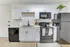 Sleek, modern kitchen with white cabinetry, black appliances, and a minimalist aesthetic.