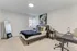Stylishly decorated bedroom with a modern desk, queen bed, and decorative wall art.