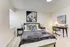 Inviting bedroom with modern decor, featuring a comfortable bed, stylish artwork, and a functional workspace.