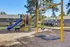 Inviting playground with slides and swings set against stylish apartment buildings and lush greenery.