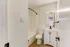 Bright modern bathroom featuring elegant fixtures, a sleek vanity, and stylish lighting.