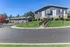 Inviting apartment complex with lush landscaping and now leasing signs.