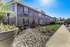 Charming apartment building exterior with well-maintained landscaping and a sunny atmosphere.