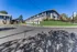 Charming two-story apartment building with well-maintained lawns and ample parking under clear blue skies.